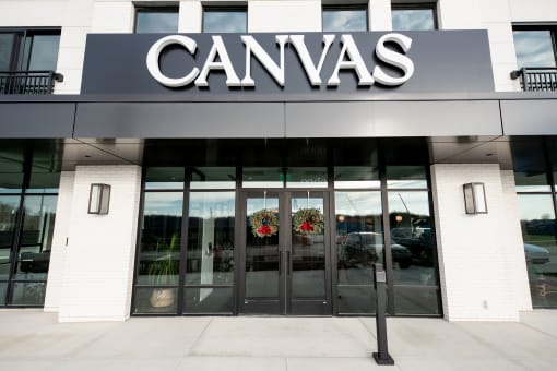 the front of a canvas building with a large sign on top of the door