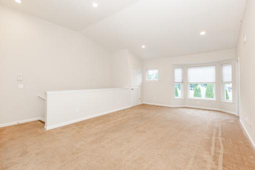 an empty living room with a white wall and window