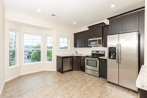 a kitchen with stainless steel appliances and black cabinets