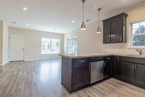 an open kitchen and living room with dark cabinets