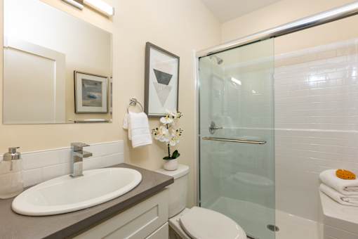 A bathroom with a sink, toilet, and shower.