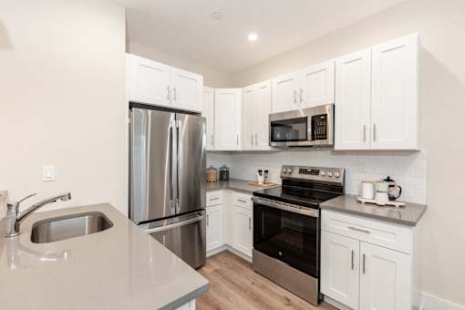 A kitchen with white cabinets and stainless steel appliances.