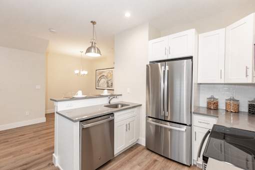 A modern kitchen with stainless steel appliances and white cabinets.