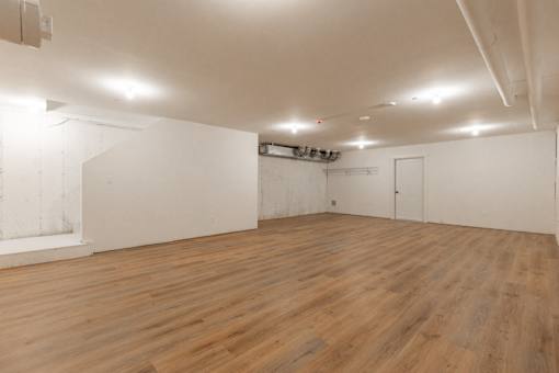 A large empty room with wooden floors and white walls.