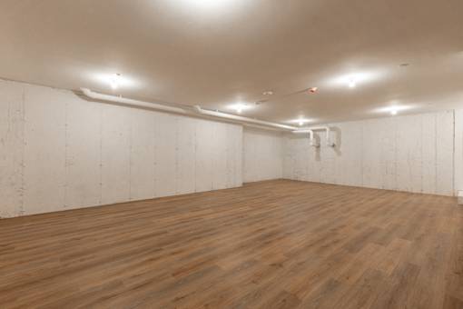 A room with wooden flooring and white walls.
