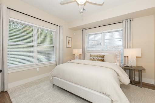 A bedroom with a large bed and a ceiling fan.