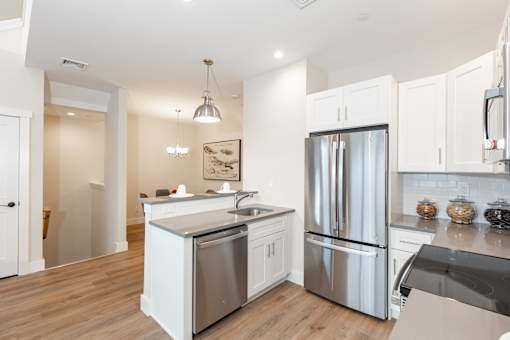 A modern kitchen with stainless steel appliances and white cabinets.