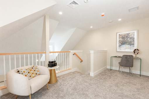 A living room with a white chair and a grey chair.