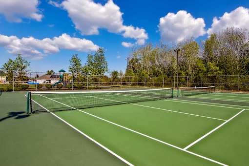 A tennis court with a green surface and white lines at Evergreen, Merrillville, 46410