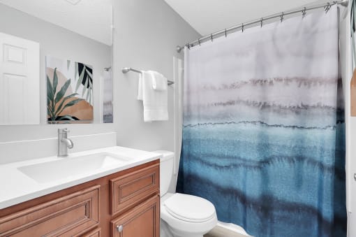 a bathroom with a toilet sink and shower at Stonewater Apartments, Louisville