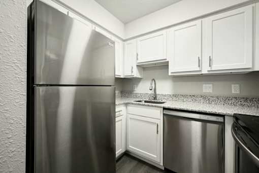 a kitchen with white cabinets and a stainless steel refrigerator at Southridge, Kansas City, KS, 66103
