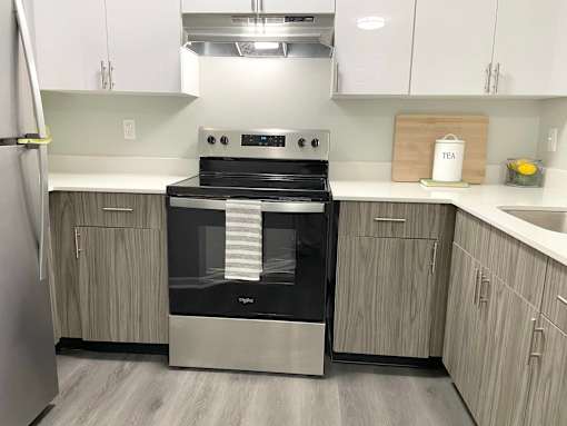 A modern kitchen with a stainless steel oven and wooden cabinets.at Vita on Grant, Merrillville, 46410