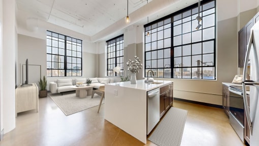 a living room with a kitchen and a lot of windows