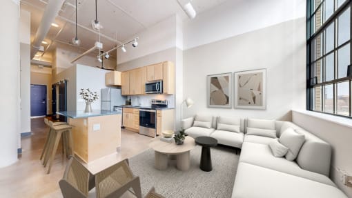 a living room and kitchen with white couches and a table