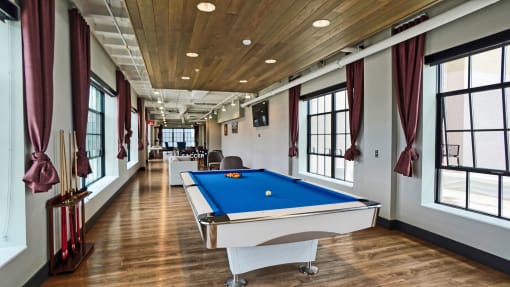 a games room with a pool table in the middle of it