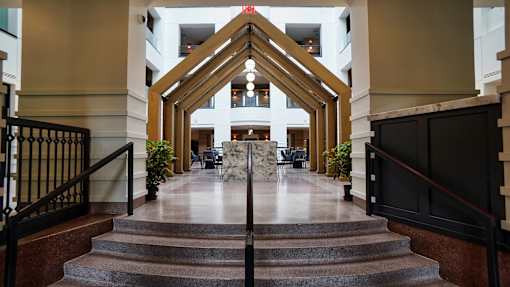a view of the lobby of a building with stairs and a table in the center