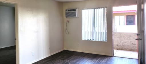 an empty room with a window and an air conditioner