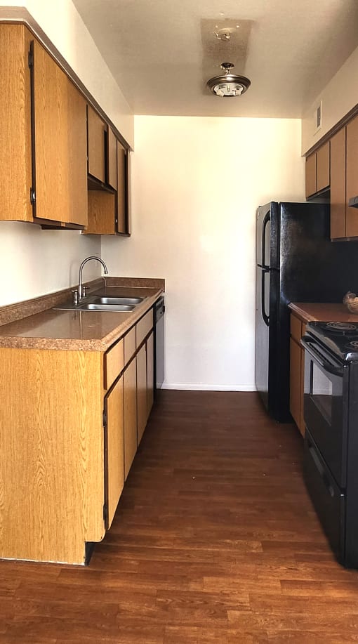 a kitchen with black appliances and wooden cabinets
