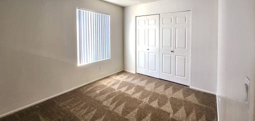 a bedroom with two closets and a window