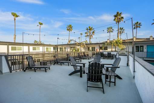 A patio with chairs and palm trees at Ocean Breeze Terrace Apartment, California