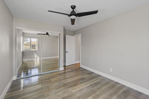 an empty living room with a ceiling fan and a window at Ocean Breeze Terrace Apartment, California, 92648