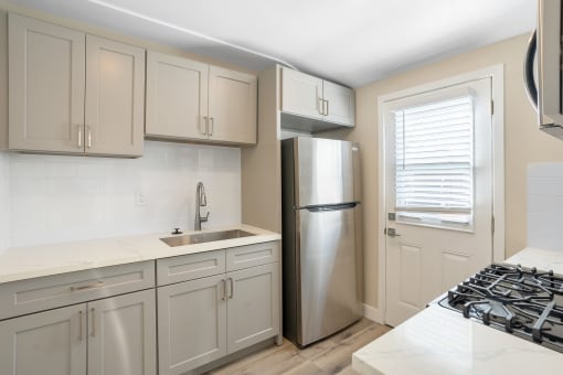a kitchen with white cabinets and a stainless steel refrigerator at Huntington Manor Homes Apartment, Huntington Beach, 92648