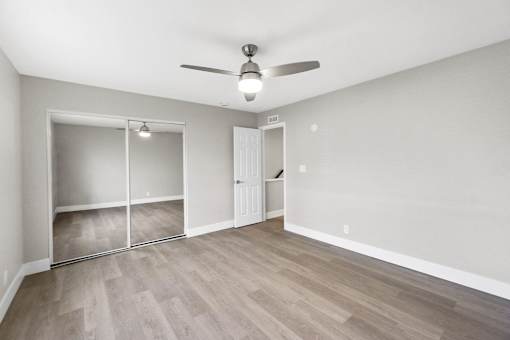 A room with a ceiling fan and sliding doors.