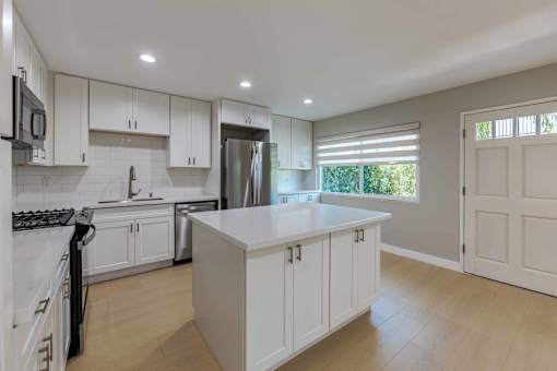 Kitchen with White Cabinets at Eastside Haven at 17th Apartments, Costa Mesa