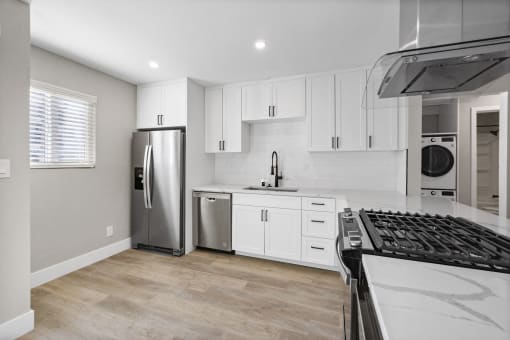 a renovated kitchen with white cabinets and stainless steel appliance at Ocean Breeze Terrace Apartment, Huntington Beach, CA, 92648
