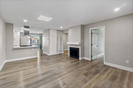 a renovated living room with a fireplace and a kitchen at Ocean Breeze Terrace Apartment, California