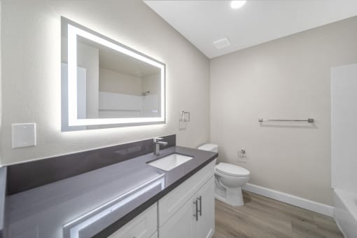 a bathroom with a large mirror and a sink and a toilet at Wescove Apartments, West Covina
