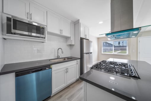 a modern kitchen with white cabinets and stainless steel appliances at Wescove Apartments, West Covina, 91790