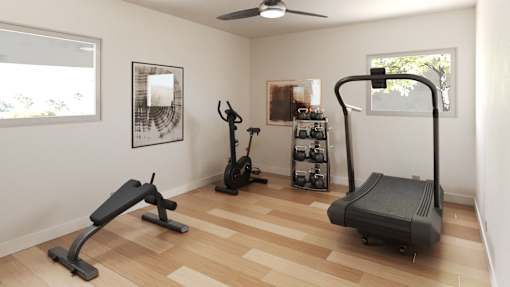 a home gym with exercise equipment in a room with wooden floors