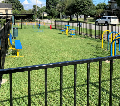 a playground is shown behind a black fence