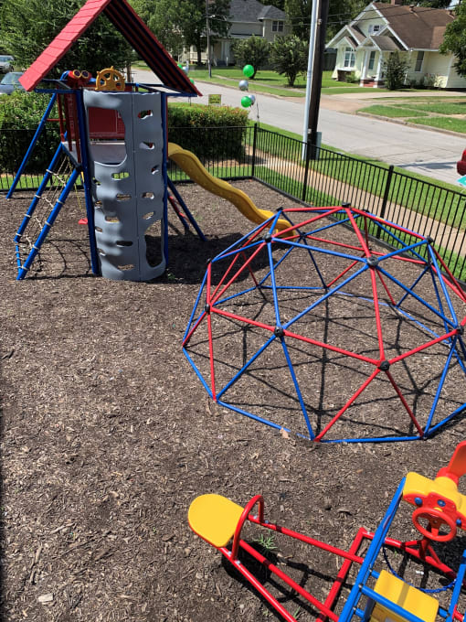 a playground with a spiderweb swing set and monkey bars