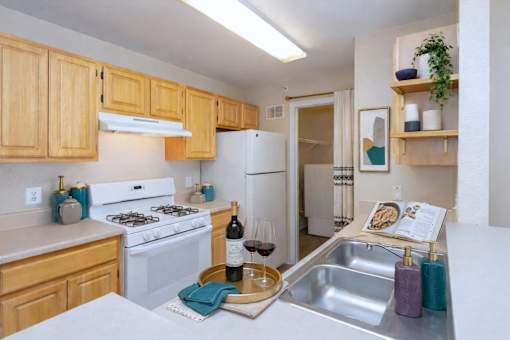 Kitchen with white appliances and light wood cabinets at Walnut Ridge Apartments, Raleigh, 27610