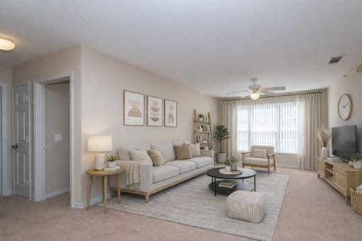Bright living room with beige sofa and carpet at Walnut Ridge Apartments, Raleigh, NC