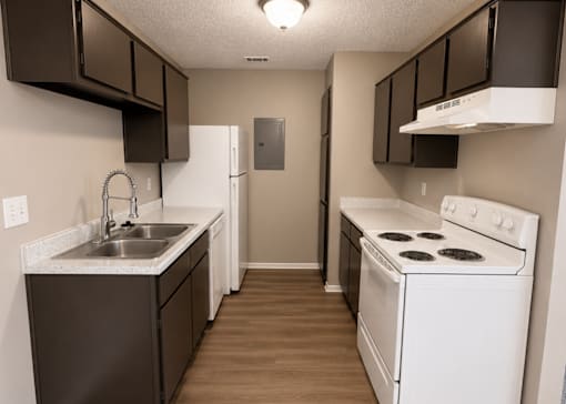 A kitchen with brown cabinets and a white stove.