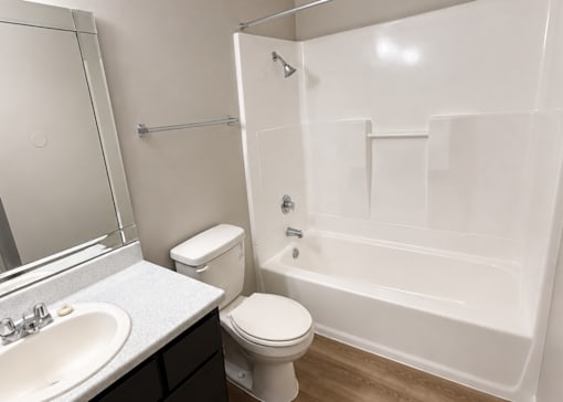 A white bathroom with a toilet, sink, and bathtub.