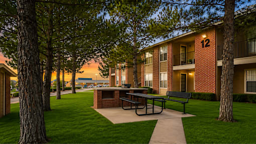 Outdoor picnic area with bbq grill and seating at Las Lomas Apartments, El Paso