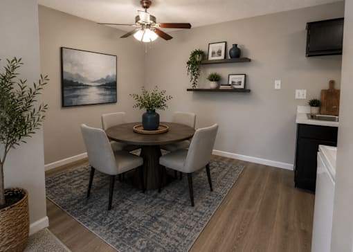A dining room with a table, chairs, and a ceiling fan.