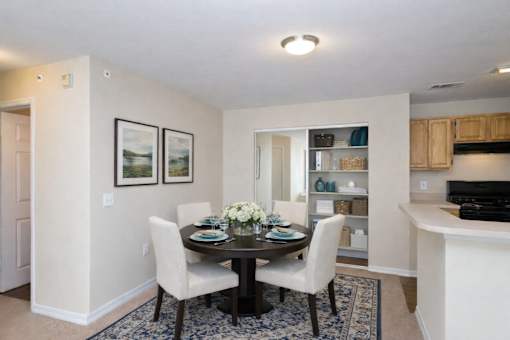 Dining room with round table and upholstered chairs at Walnut Ridge Apartments, North Carolina