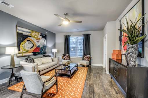 A living room with a large painting on the wall and a sofa.