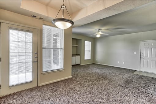 A living room with a ceiling fan and window in Arlington, TX.
