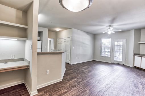 A spacious room with a ceiling fan and a large window in Arlington, TX.
