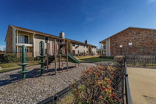 Community playground with apartment buildings in background at The Finley Apartments, Dallas, TX 75228