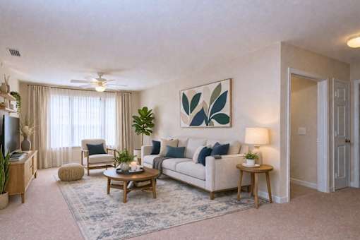 Living room with neutral sofa and botanical artwork at Walnut Ridge Apartments, Raleigh, NC 27610