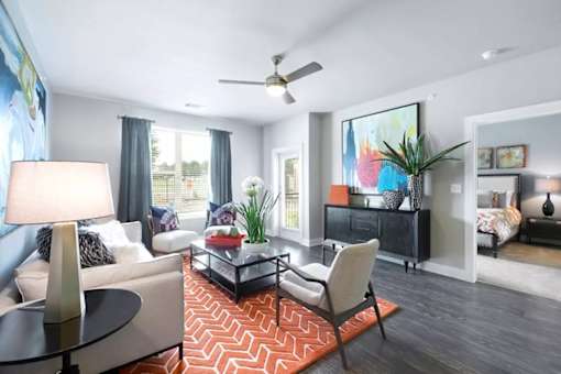 A living room with a white couch, a black coffee table, and a ceiling fan.