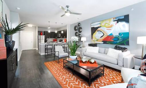 A living room with a white couch and a painting on the wall.