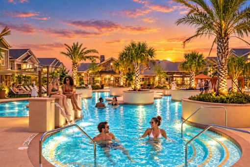 A group of people are enjoying a swim in a pool at a resort.